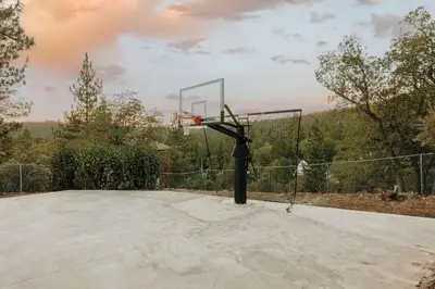 a basketball hoop on top of a cement court at Lakeside Lodge - Deck Views, Golf, Basketball, Spa in Fawnskin