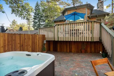 a hot tub in a backyard with a wooden fence at Acorn Cottage in Big Bear Lake