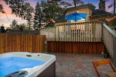 a hot tub in a yard next to a house at Acorn Cottage in Big Bear Lake