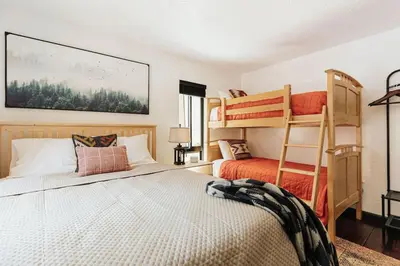 a bedroom with two bunk beds and a bed at Solace Cabin in Big Bear Lake