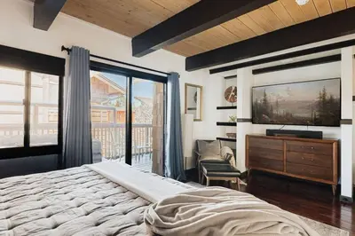 a bedroom with a large bed and a dresser at Solace Cabin in Big Bear Lake