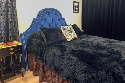 a bed with a blue headboard and a night stand at Walk to Hollywood Blvd Chic LA Studio with Patio! in Los Angeles