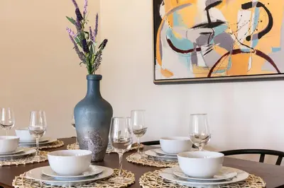 a table with plates and glasses and a vase with flowers at Unwind in Spacious 2BR Apt Sleeps 6 with Parking in Glendale