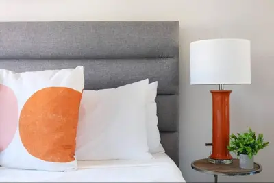 a bed with white pillows and a lamp at Luxury 3BR Condo Near Americana and Galleria in Glendale