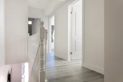 a hallway with white walls and a white staircase at Relax in Spacious 3BR Apt Sleeps 8 and Parking in Glendale