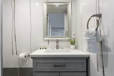 a white bathroom with a sink and a mirror at Modern 3BR Apt with Parking in Glendale in Glendale