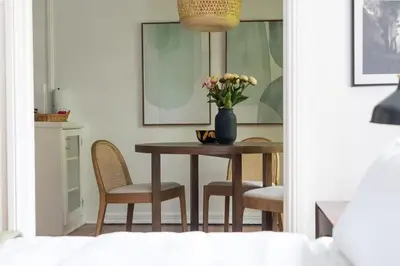 a dining room table with chairs and a vase of flowers at Furnished Studio in Hollywood in Los Angeles