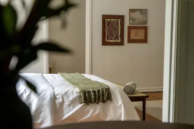 a bedroom with a bed with a green blanket on it at Furnished Studio in Hollywood in Los Angeles