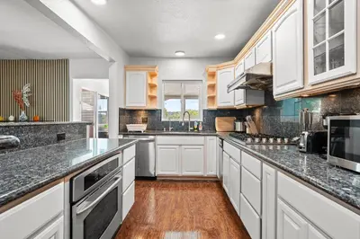 a kitchen with white cabinets and a wooden floor at Spacious Family Retreat in San Dimas Great Location in Covina