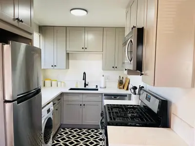 a kitchen with white cabinets and a stove top oven at Remodeled Bixby Knolls 2 bedroom unit - Close to shopping in Long Beach