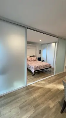 a bedroom with a bed and glass walls at Joyful Place in Sherman Oaks