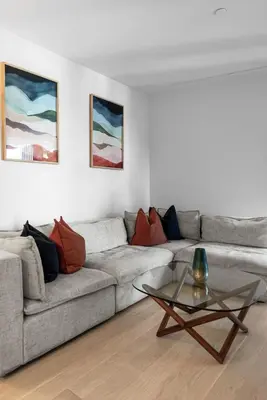 a living room with a couch and a glass table at Pearl Coast - Modern 2BR with Rooftop Pool & Views in Los Angeles