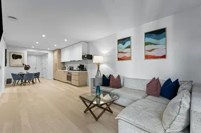 a living room with a couch and a table at Pearl Coast - Modern 2BR with Rooftop Pool & Views in Los Angeles