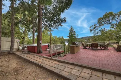 a patio with a table and benches and trees at Emerald Arrowhead Haus - For 6 in Lake Arrowhead