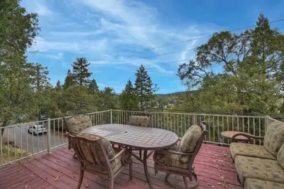 a patio with a table and chairs on a deck at Emerald Arrowhead Haus - For 6 in Lake Arrowhead