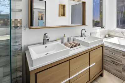 a bathroom with two sinks and two mirrors at Hollywood Hills Luxury Mansion with Pool & Views in Los Angeles