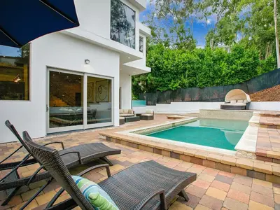 a backyard with a swimming pool and a house at Hollywood Hills Luxury Mansion with Pool & Views in Los Angeles