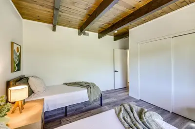 a bedroom with a bed and a sliding door at Deck and Views Modern Cabin Near Lake Arrowhead! in Lake Arrowhead