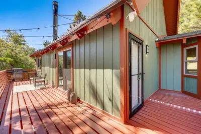 a house with a wooden deck with a door at Deck and Views Modern Cabin Near Lake Arrowhead! in Lake Arrowhead