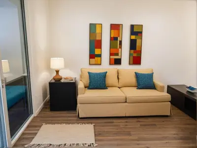a living room with a couch and paintings on the wall at Stylish Venice Escape Near the Marina & Beachfront in Los Angeles