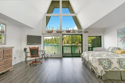 a bedroom with a bed and a large window at Lakeside Comfort condo in Lake Arrowhead