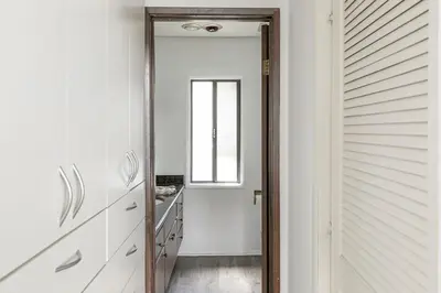 a door leading to a hallway with white cabinets and a window at Lakeside Comfort condo in Lake Arrowhead