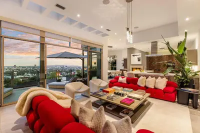 a living room with a red couch and a table at Chateau Lumier by Stay Awhile in Los Angeles
