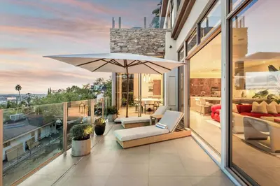a patio with an umbrella on a balcony at Chateau Lumier by Stay Awhile in Los Angeles