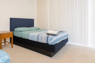 a bedroom with a bed with a blue and white blanket at Cozy Home Close to Disney in Orange