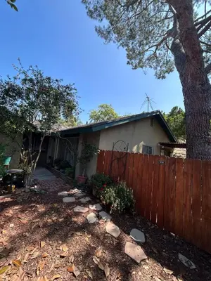 a house with a fence and a tree at Spacious Fully Furnished 3BR Fully Fenced Home in Riverside