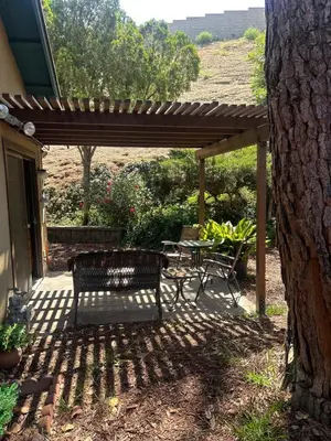 a patio with a table and a bench under a pergola at Spacious Fully Furnished 3BR Fully Fenced Home in Riverside
