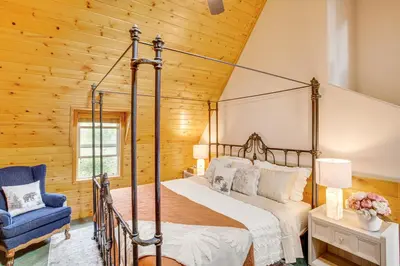 a bedroom with a canopy bed and a blue chair at 3 Mi to Snow Summit Charming Home with Fenced Yard in Big Bear Lake