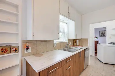 a kitchen with white cabinets and a sink at High Walkability! Extended Stay in Riverside in Riverside