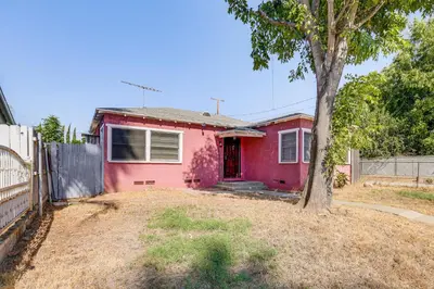 a pink house with a tree in a yard at High Walkability! Extended Stay in Riverside in Riverside