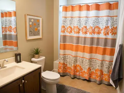 an orange and white bathroom with a toilet and shower curtain at 3 bedroom Home Casa Serenity Central Los Angeles in Los Angeles