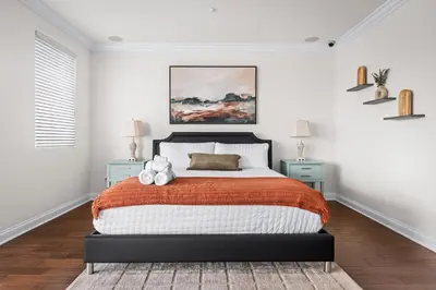 a bedroom with a bed and two blue night stands at Modern Hilltop Retreat in Lakeside Park