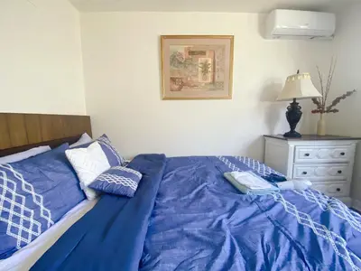 a bed with blue sheets and pillows in a bedroom at Pomona Cozy Queen Bedroom in Pomona