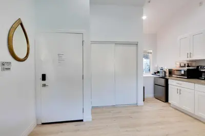 a kitchen with white cabinets and a white door at Walk to Main St! Pet-Friendly Alhambra Studio in Alhambra