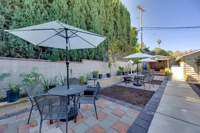 a patio with tables and chairs and an umbrella at Walk to Main St! Pet-Friendly Alhambra Studio in Alhambra