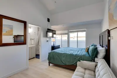a bedroom with a bed and a couch and a mirror at Walk to Main St! Pet-Friendly Alhambra Studio in Alhambra