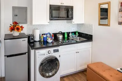 a kitchen with a washing machine and a sink at Remodeled Chick Studio Near Downtown LA, AC, WiFI, WD, Snack in Los Angeles