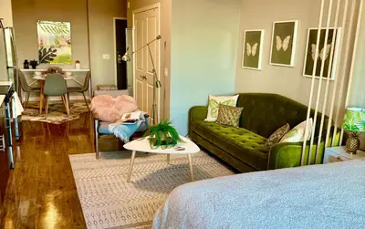 a living room with a green couch and a table at Stylish Studio in Mid-Wilshire with Pool, Free Parking, Gym in Prime Location in Los Angeles