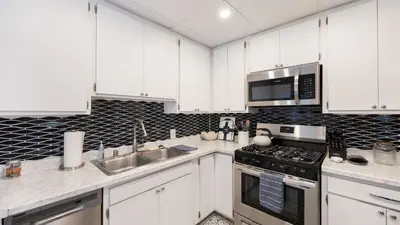 a kitchen with white cabinets and a stove top oven at Cozy Hollywood Hideaway w Private Patio Easy City Access Casa Camrose by AvantStay in Los Angeles