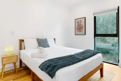 a bedroom with a bed with a green blanket on it at Platinum Suite LA in Los Angeles