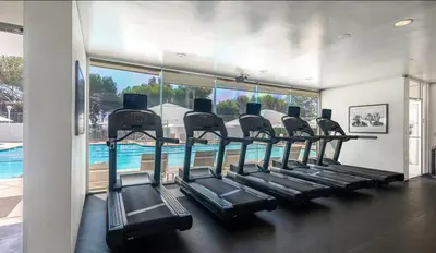 a row of treadmills in a gym with a swimming pool at Santa Monica Ocenfront 2 Bedroom Villa with Parking in Los Angeles