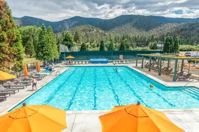 a large swimming pool with chairs and umbrellas at Walk to Village! Romantic Pine Mtn Nature Escape in Pine Mountain Club