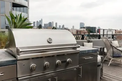 a grill on a rooftop with a view of a city at High End Hotel Style 2B apartment with two balconies in Los Angeles