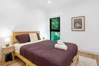 a bedroom with a large bed with a teddy bear on it at Sky Haus LA in Los Angeles