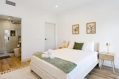 a bedroom with a white bed and a couch at Sky Haus LA in Los Angeles