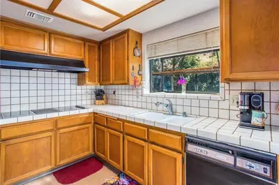 a kitchen with wooden cabinets and a window at Pet friendly 3BR Spacious Home EV in Riverside